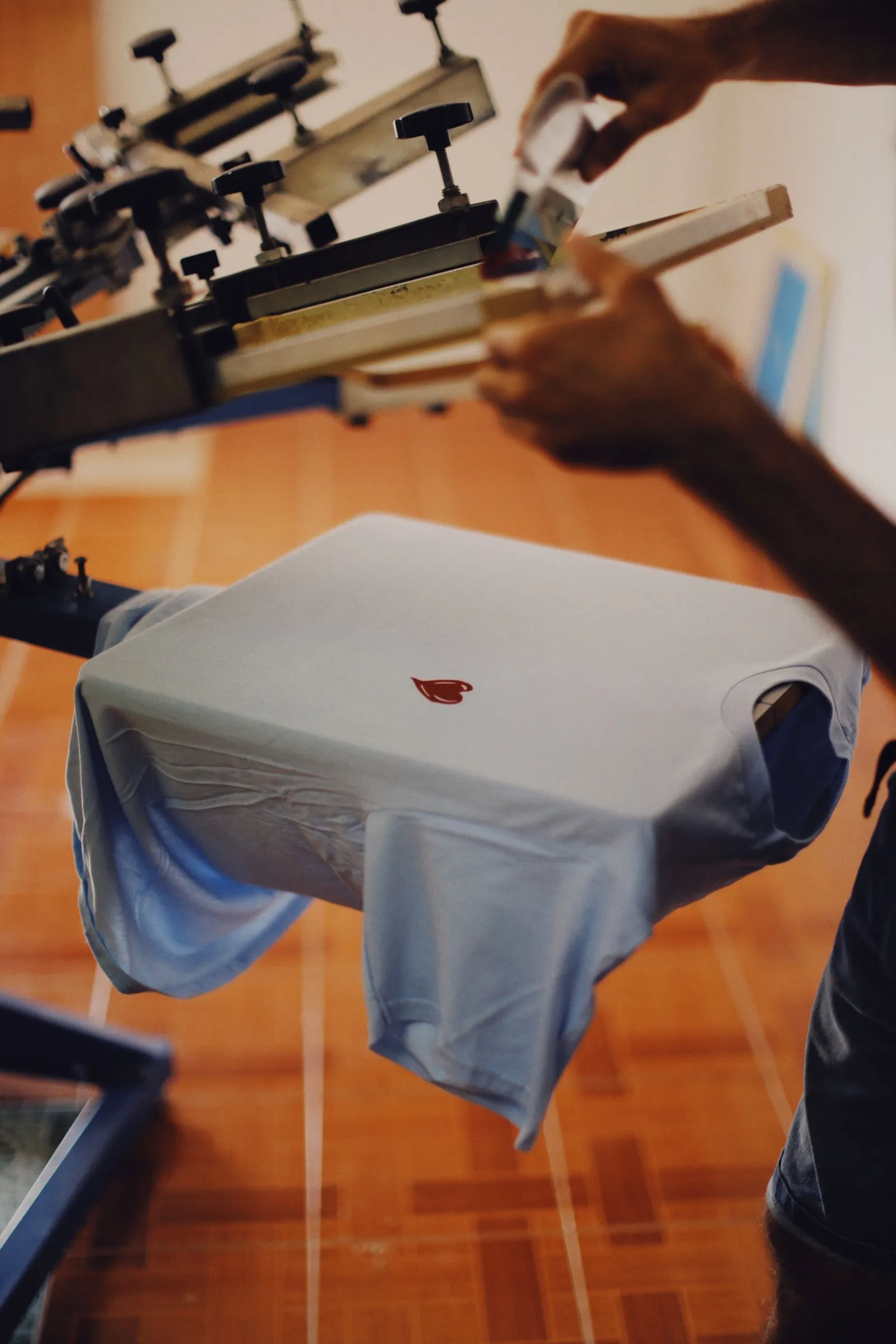 A printer working a tee on the screen-printing carousel